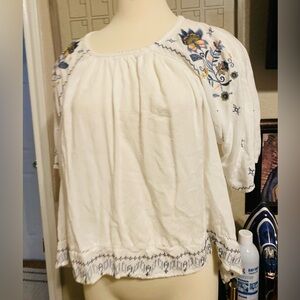 Beautiful white blouse boho style with flowers by the shoulders